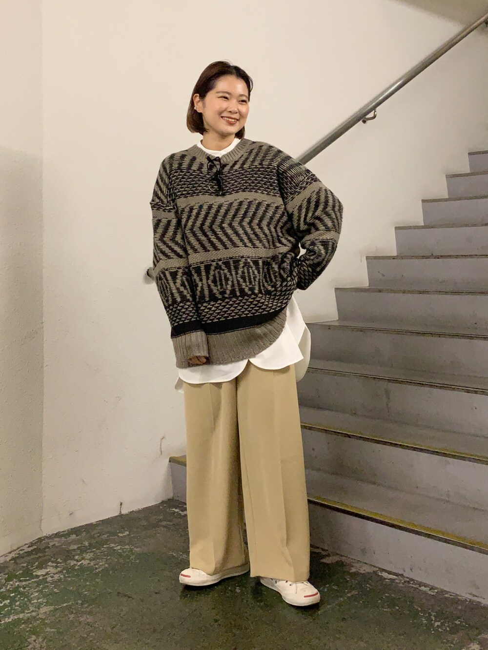 ホワイト系のスニーカー、ベージュ系のパンツ、ブラウン系のニット/セーターを着用したレディースの冬コーディネートの3枚目の写真