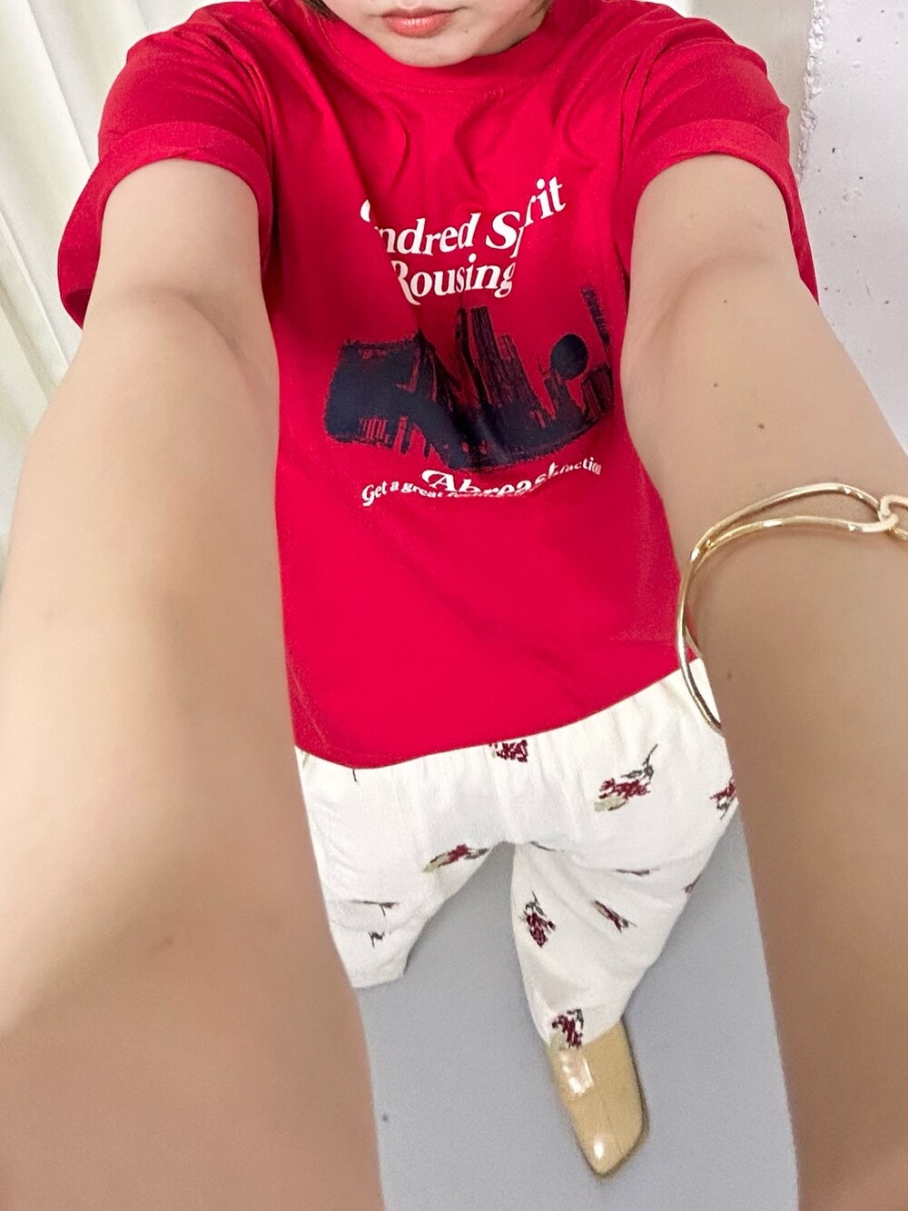 レッド系のTシャツ/カットソー、ホワイト系のその他パンツ、ゴールド系のバングル/リストバンドを着用したレディースの夏コーディネートの2枚目の写真