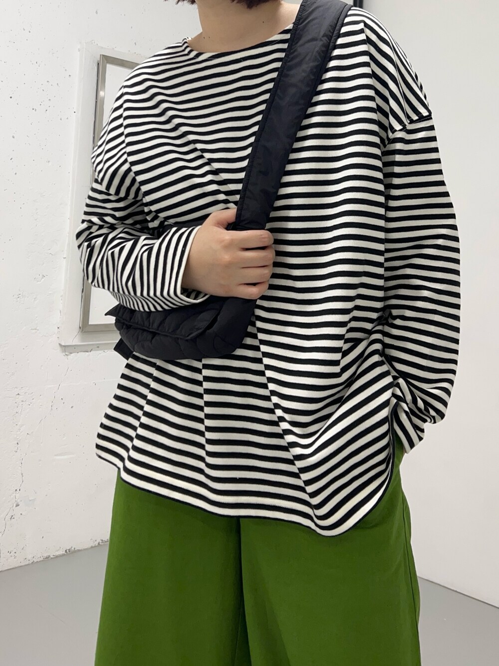 ホワイト系のTシャツ/カットソー、グリーン系のその他パンツ、ブラック系のショルダーバッグを着用したレディースの冬コーディネートの3枚目の写真