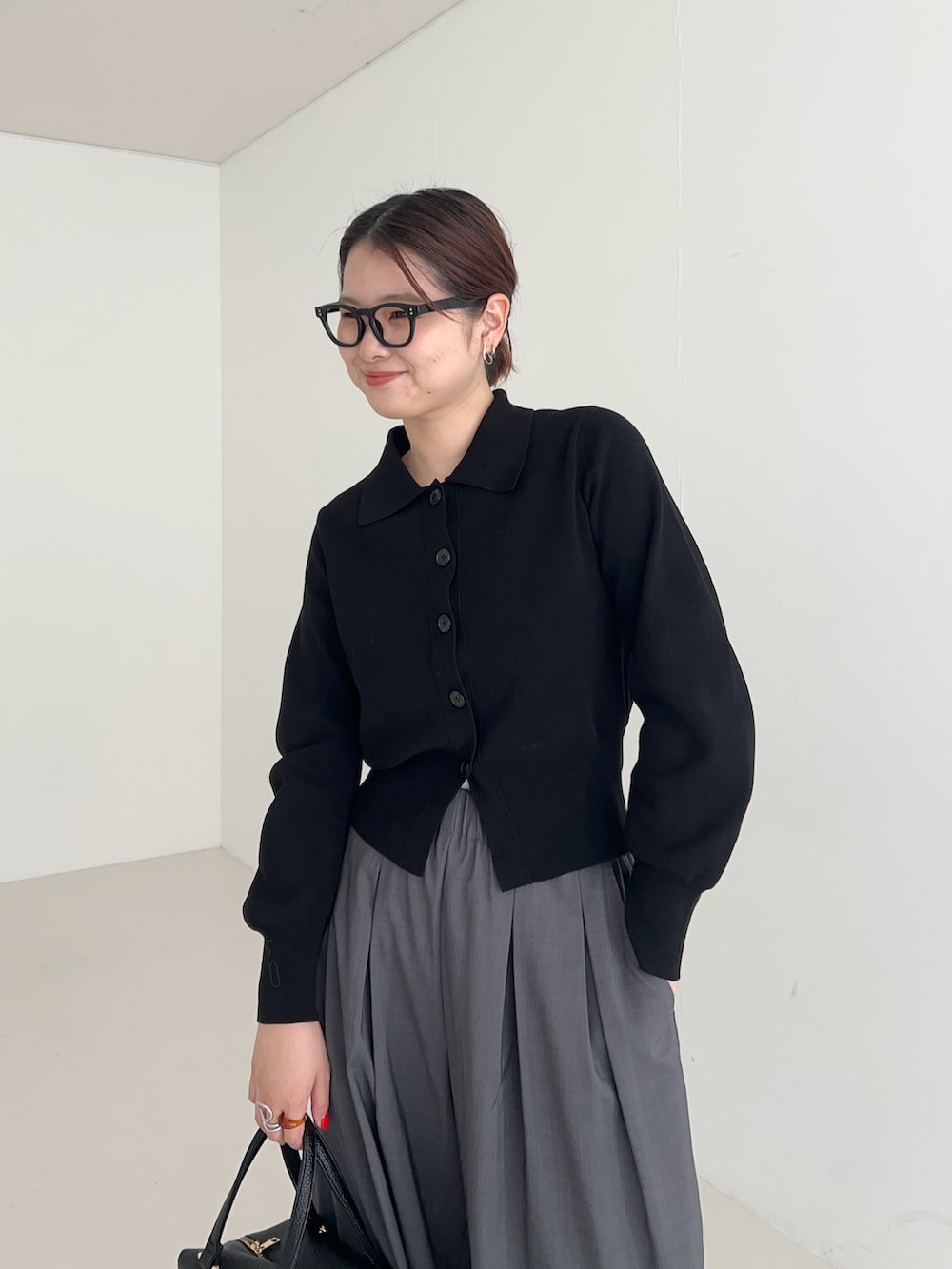 グレー系のその他パンツ、ブラック系のカーディガン/ボレロ、ブラック系のハンドバッグを着用したレディースの秋コーディネートの5枚目の写真