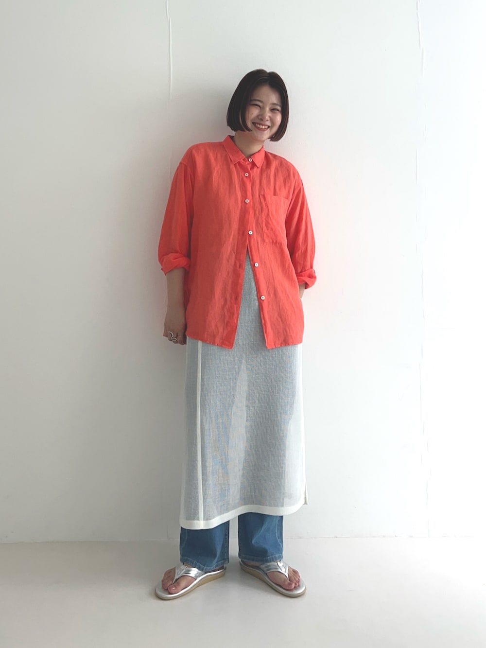 ホワイト系のスカート、ブルー系のデニムパンツ、オレンジ系のシャツ/ブラウスを着用したレディースの夏コーディネートの2枚目の写真