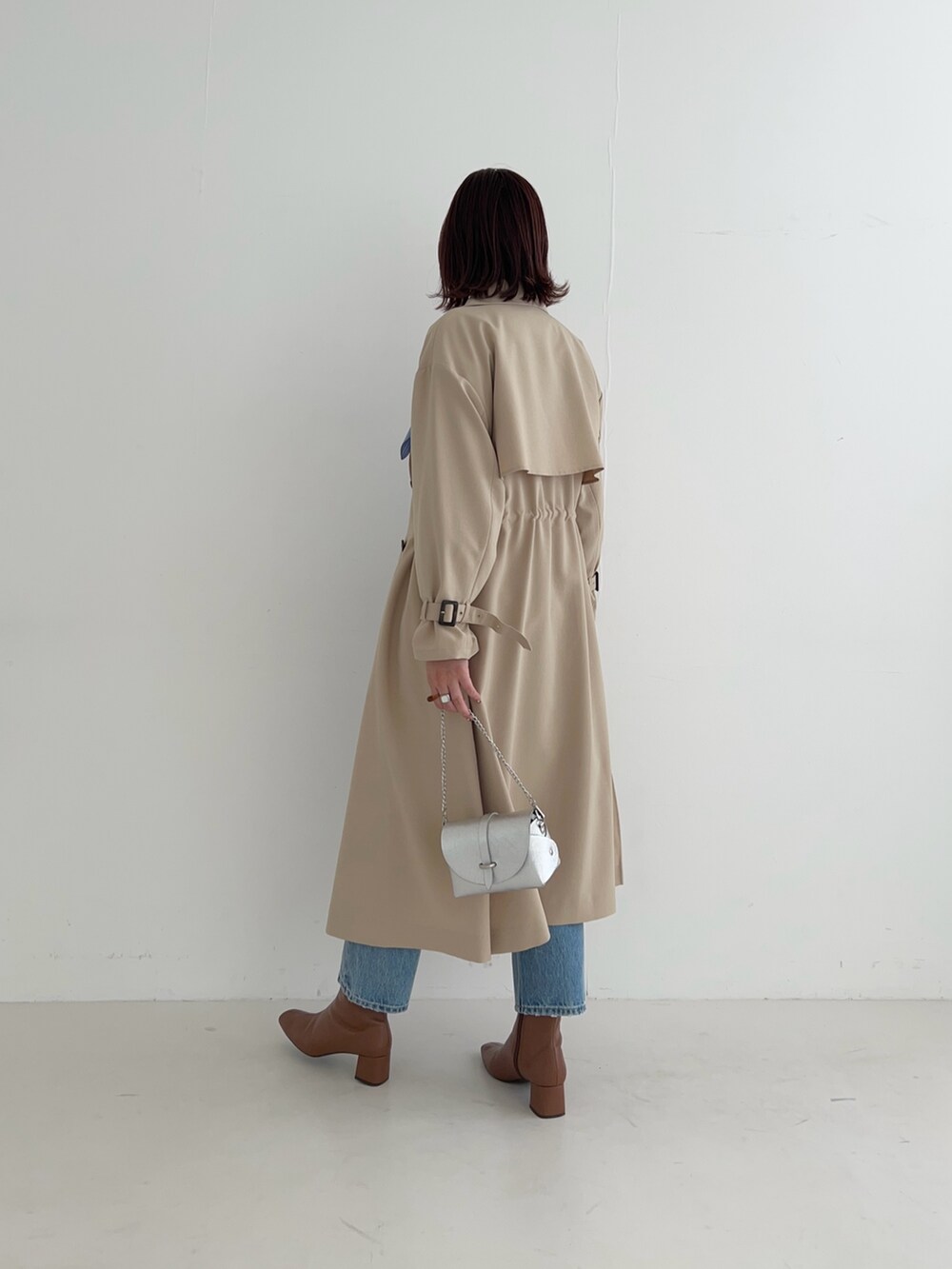 ベージュ系のトレンチコート、ブルー系のデニムパンツ、その他のシャツ/ブラウスを着用したレディースの冬コーディネートの4枚目の写真