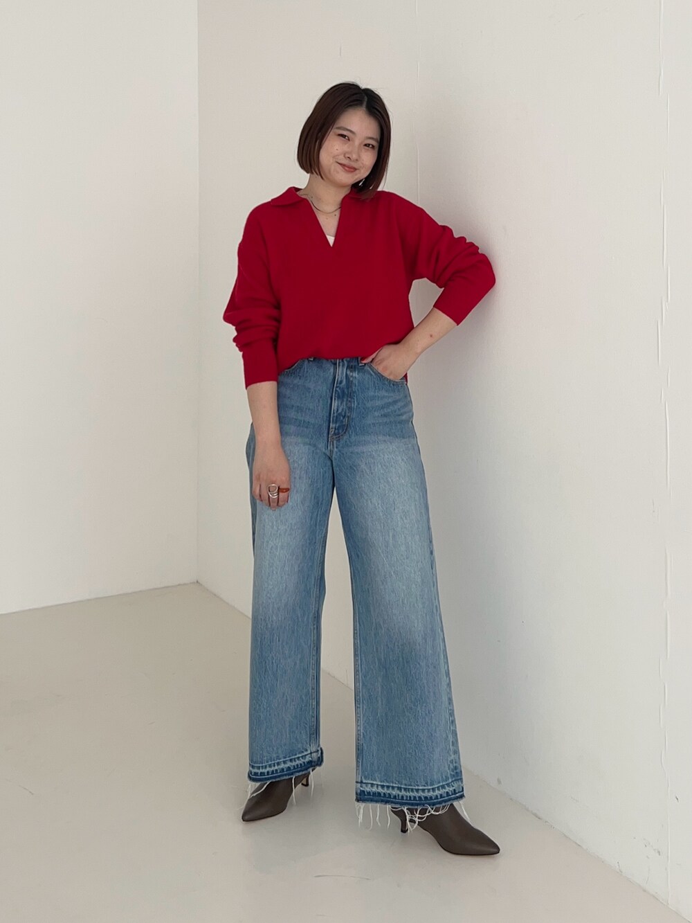 ブルー系のデニムパンツ、レッド系のニット/セーターを着用したレディースの秋コーディネートの4枚目の写真