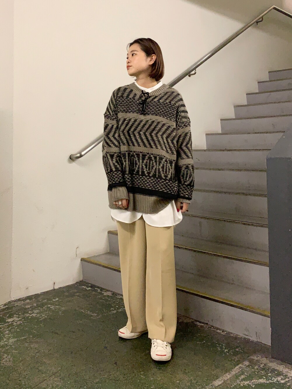 ホワイト系のスニーカー、ベージュ系のパンツ、ブラウン系のニット/セーターを着用したレディースの冬コーディネートの2枚目の写真