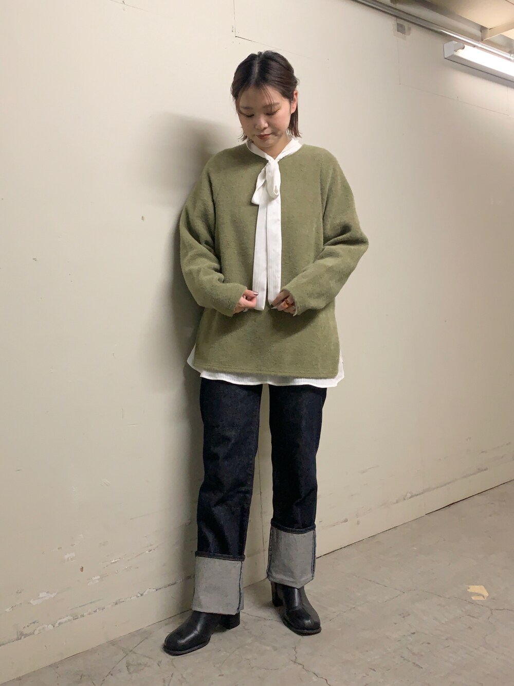 ブルー系のデニムパンツ、ホワイト系のシャツ/ブラウス、グリーン系のTシャツ/カットソーを着用したレディースの冬コーディネートの2枚目の写真