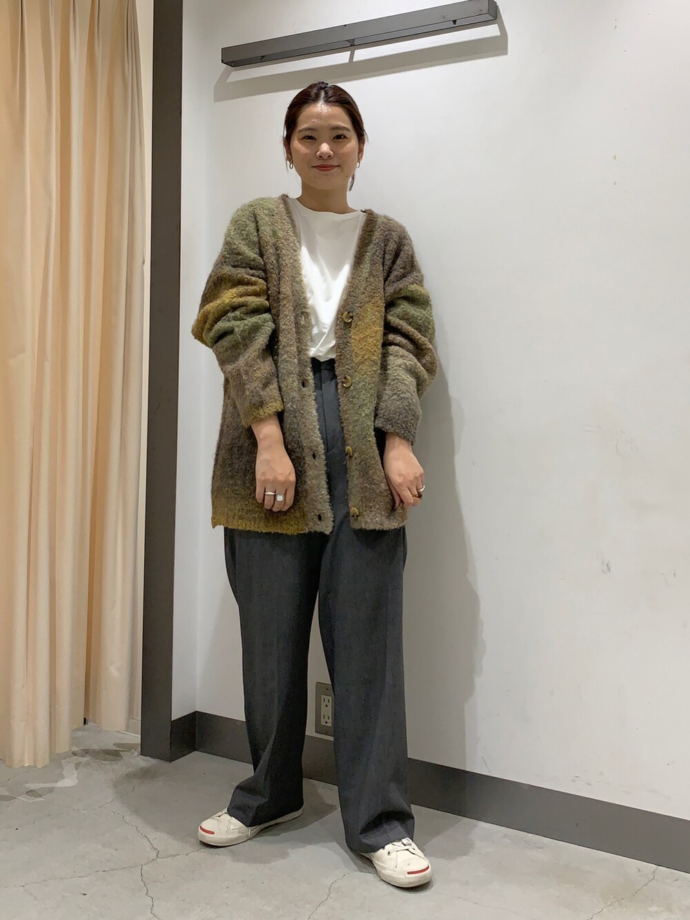 ブラウン系のカーディガン/ボレロ、ホワイト系のTシャツ/カットソー、ホワイト系のスニーカーを着用したレディースの秋コーディネートの2枚目の写真