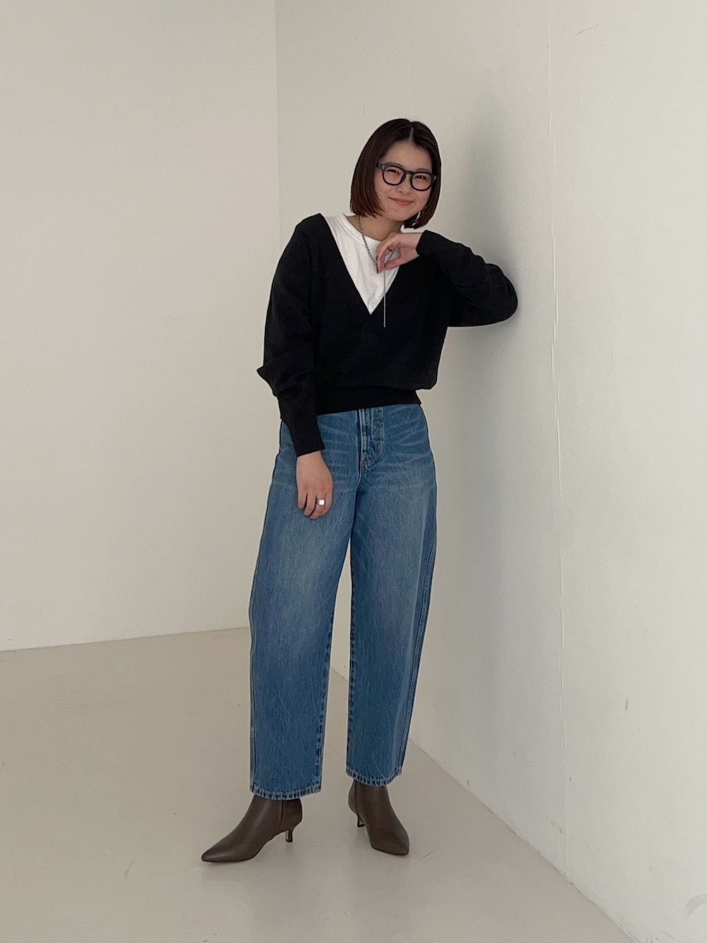 ブルー系のデニムパンツ、グレー系のニット/セーターを着用したレディースの秋コーディネートの2枚目の写真