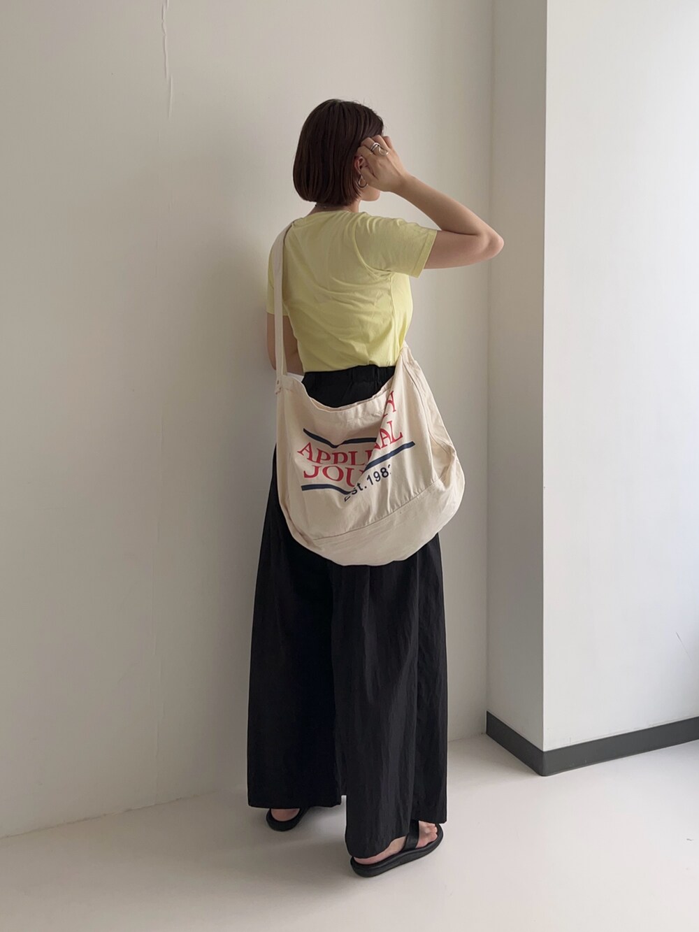 イエロー系のTシャツ/カットソー、ブラック系のその他パンツを着用したレディースの夏コーディネートの3枚目の写真