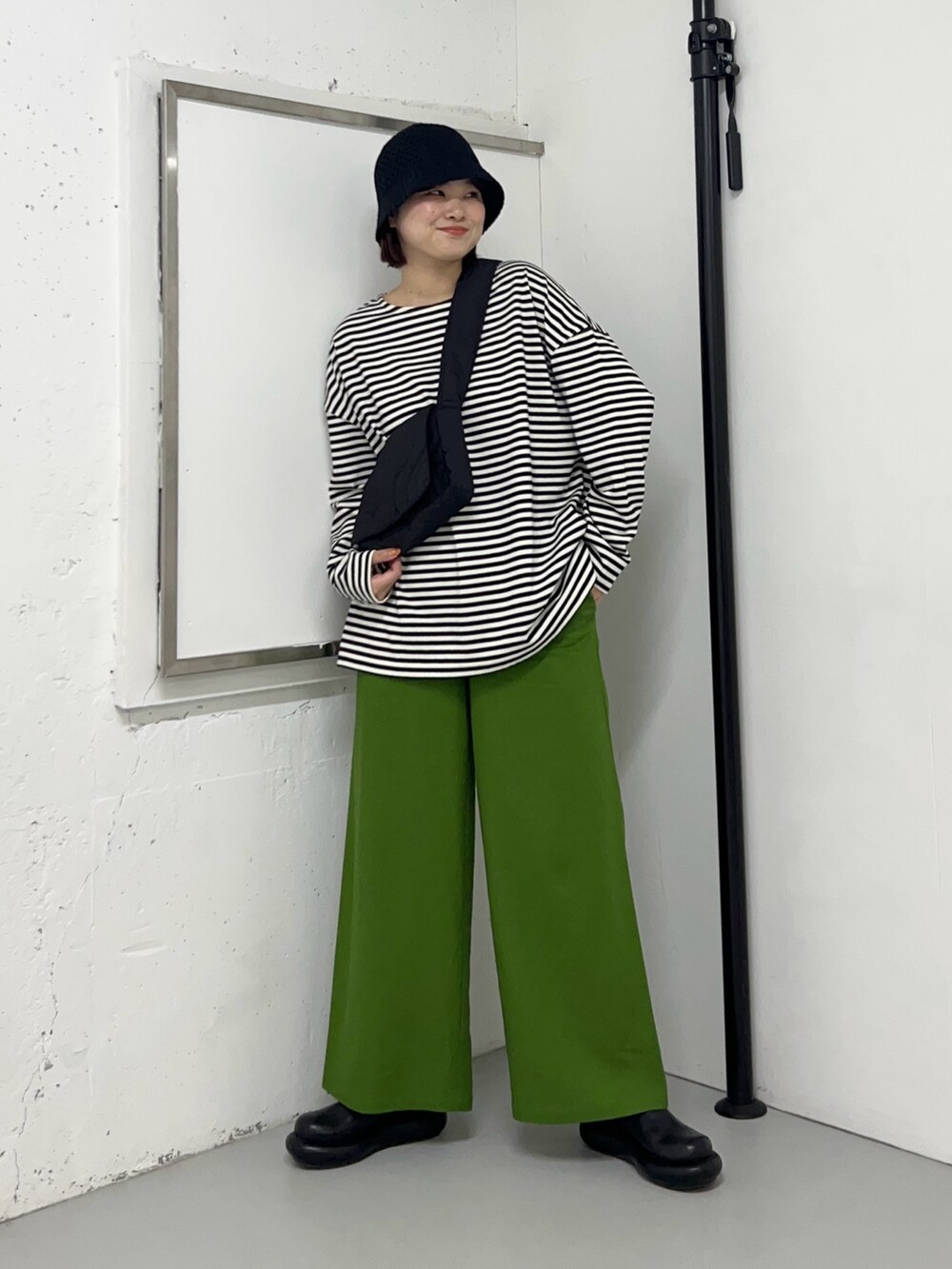 ホワイト系のTシャツ/カットソー、グリーン系のその他パンツ、ブラック系のショルダーバッグを着用したレディースの冬コーディネートの2枚目の写真