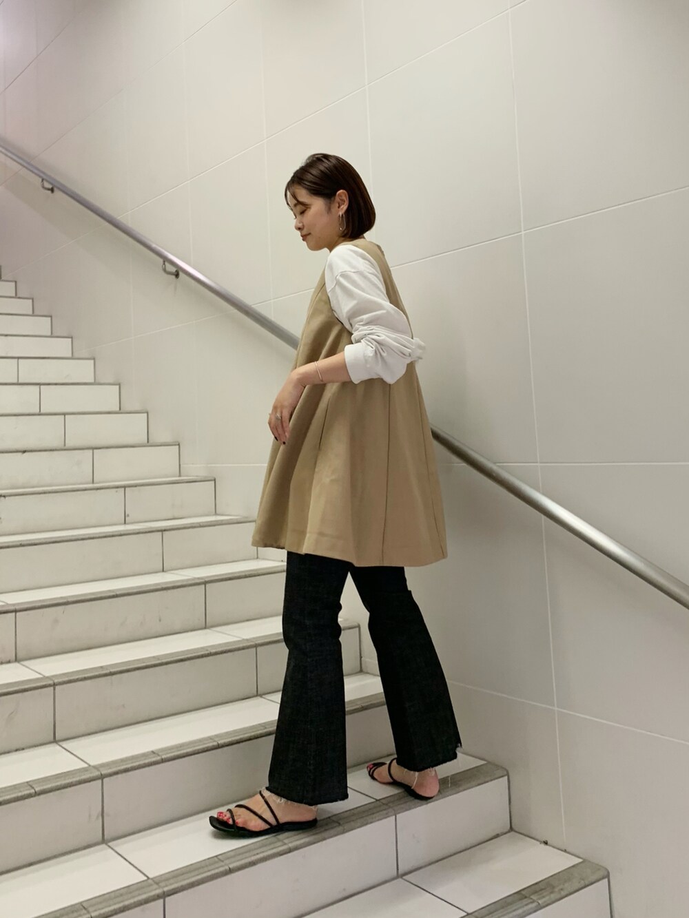 ブラック系のパンツ、ベージュ系のワンピース/ドレス、グリーン系のトートバッグを着用したレディースの夏コーディネートの2枚目の写真