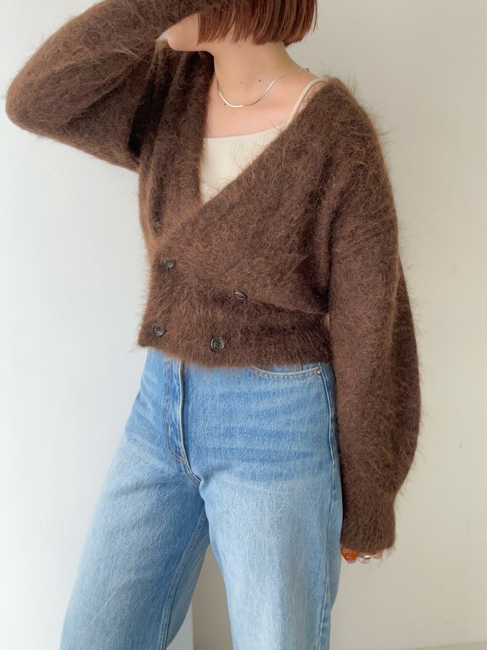 ブラウン系のカーディガン/ボレロ、ブルー系のデニムパンツを着用したレディースの秋コーディネートの3枚目の写真