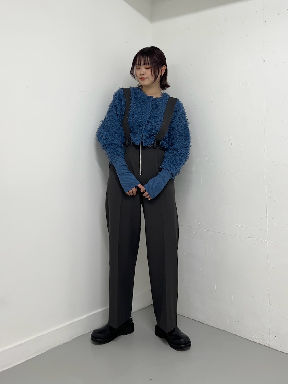 グレー系のサロペット/オーバーオール、ブルー系のカーディガン/ボレロ、ブラック系のブーツを着用したレディースの冬コーディネートの2枚目の写真