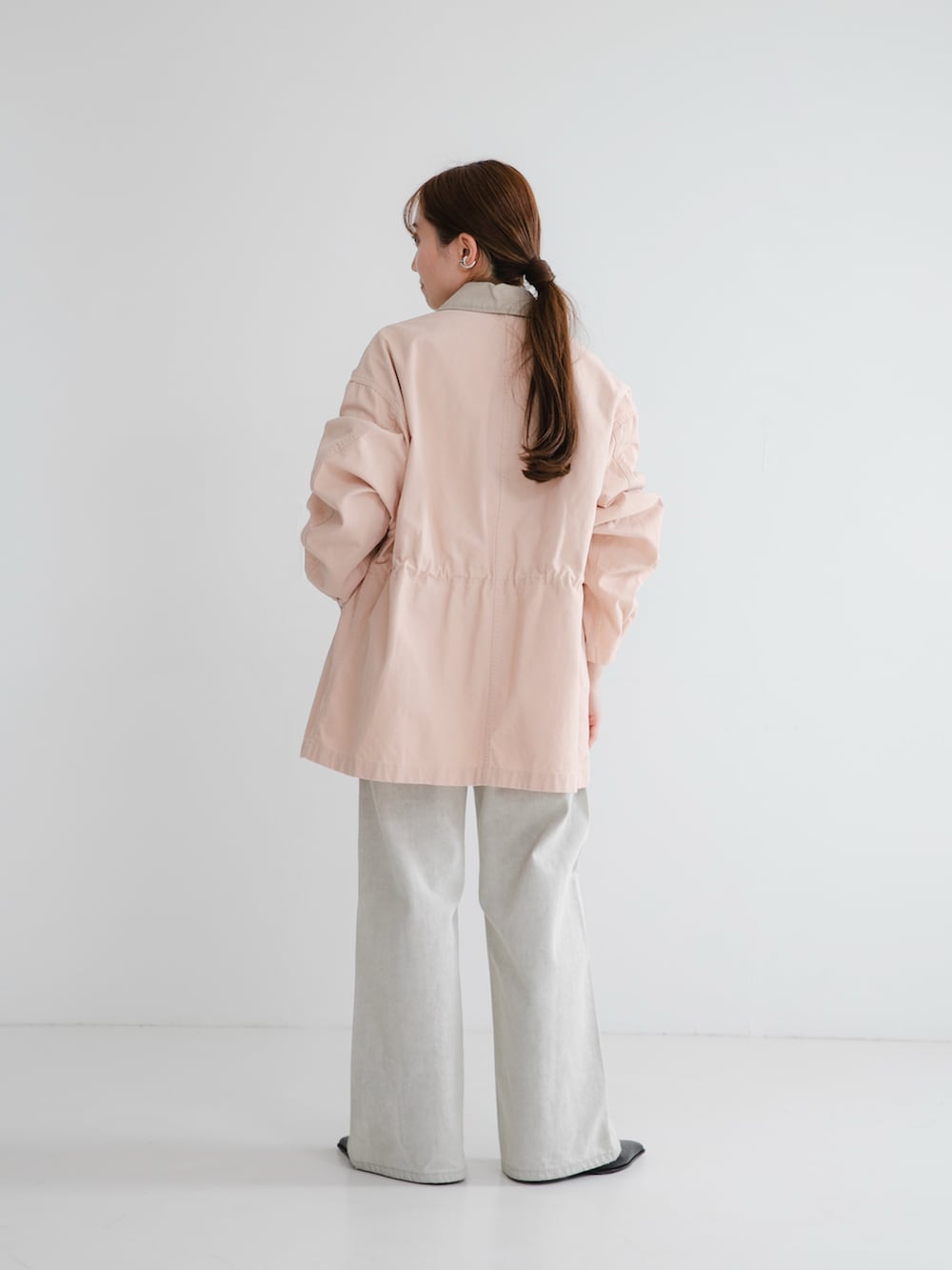 ブラック系のパンプス、ホワイト系のスウェット、グレー系のデニムパンツを着用したレディースの冬コーディネートの2枚目の写真