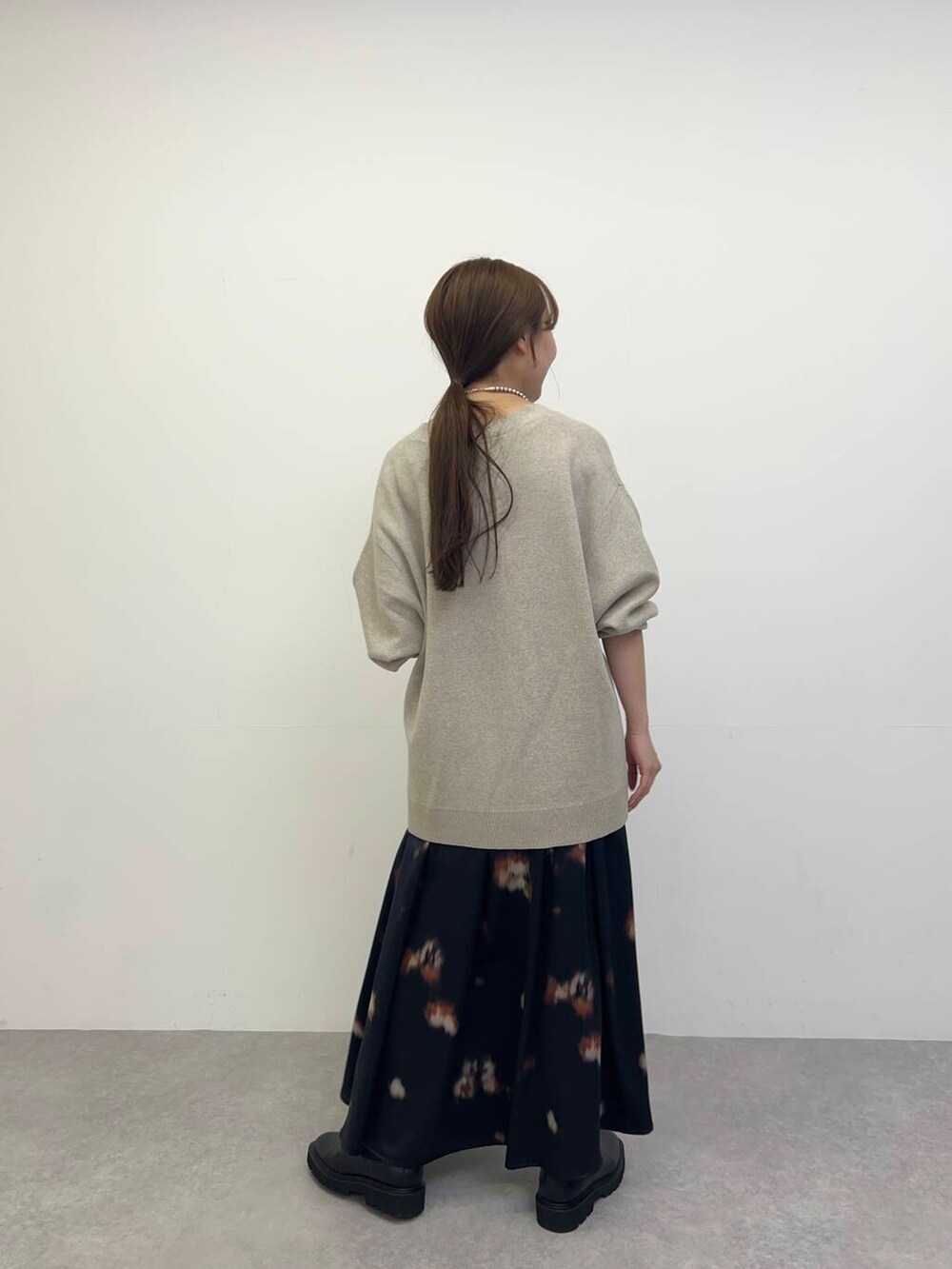 ホワイト系のキャミソール、ベージュ系のカーディガン/ボレロ、ブラック系のブーツを着用したレディースの秋コーディネートの3枚目の写真