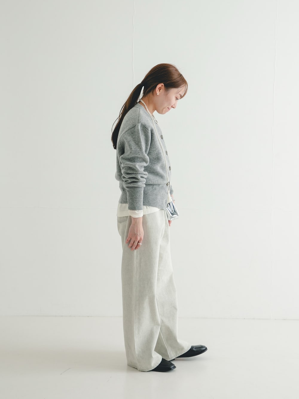 ホワイト系のTシャツ/カットソー、ブラック系のローファー、グレー系のデニムパンツを着用したレディースの冬コーディネートの2枚目の写真