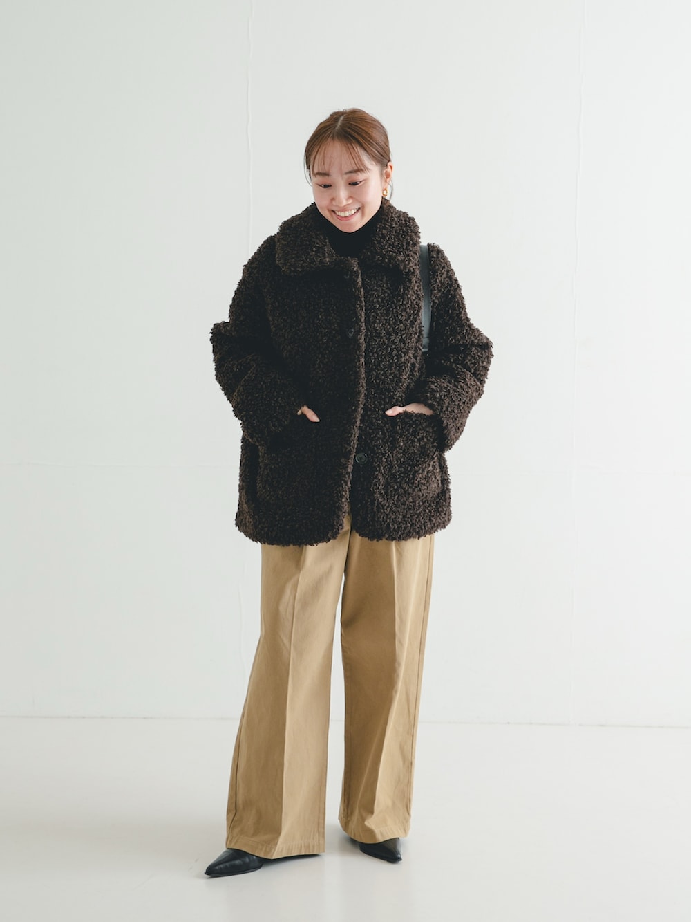 ブラック系のブーツ、ブラウン系のその他アウター、ブラック系のニット/セーターを着用したレディースの冬コーディネートの2枚目の写真