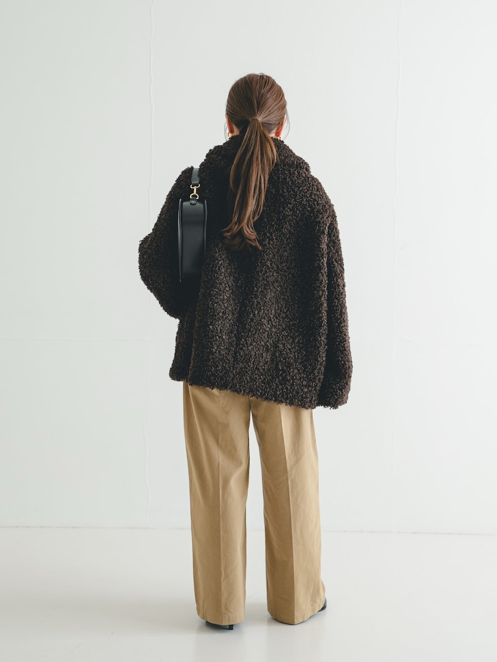 ブラック系のブーツ、ブラウン系のその他アウター、ブラック系のニット/セーターを着用したレディースの冬コーディネートの4枚目の写真