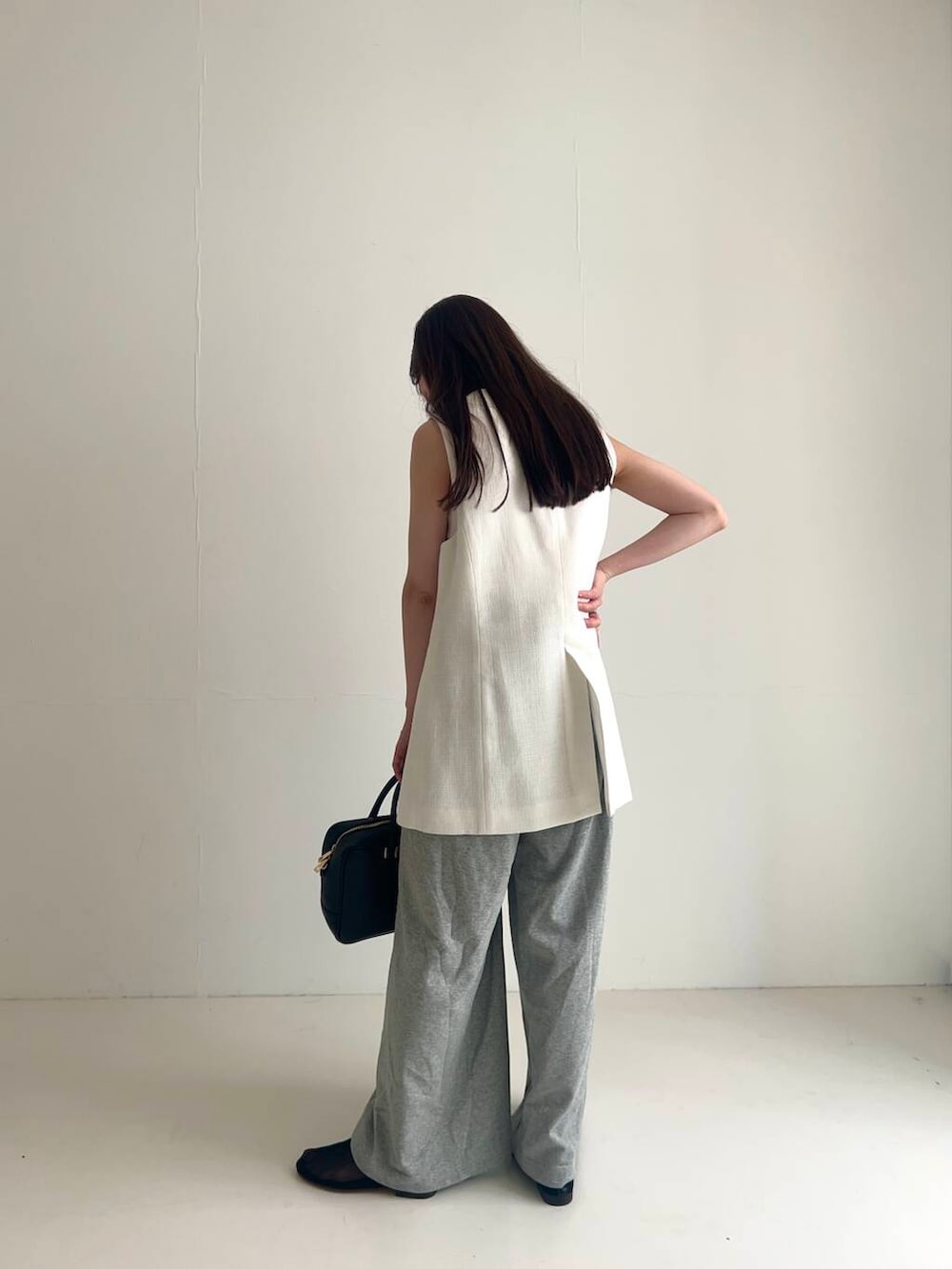 ホワイト系のベスト、ブラック系のバレエシューズ、グレー系のその他パンツを着用したレディースの夏コーディネートの2枚目の写真