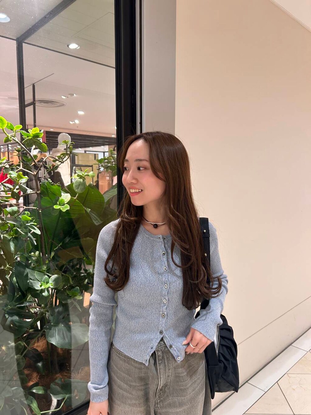 グリーン系のデニムパンツ、ブルー系のニット/セーター、ブラック系のブーツを着用したレディースの冬コーディネートの3枚目の写真