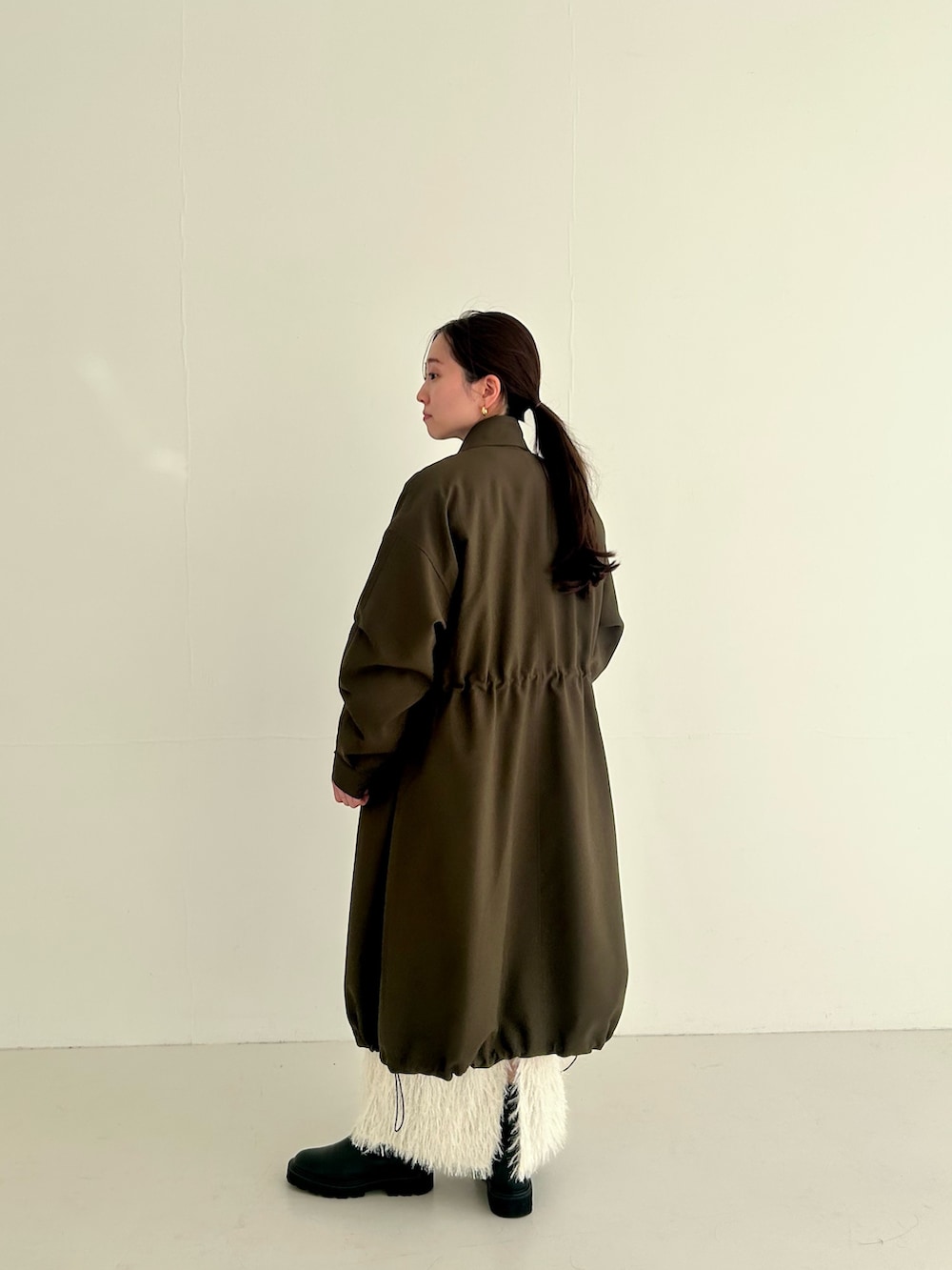 グリーン系のその他アウターを着用したレディースの秋コーディネートの2枚目の写真