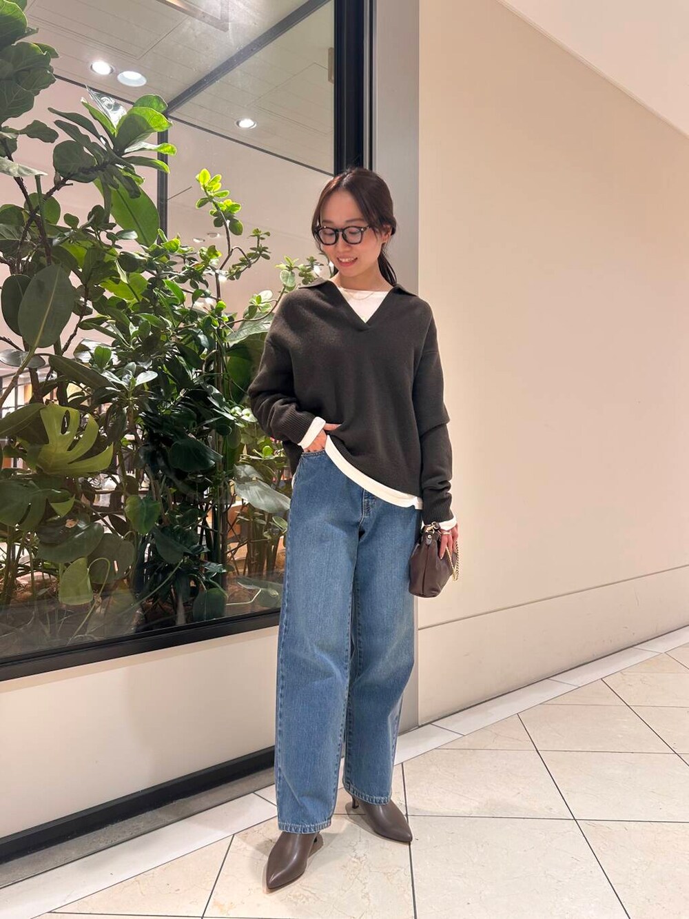 ブルー系のデニムパンツ、ブラウン系のニット/セーター、ブラウン系のブーツを着用したレディースの冬コーディネートの4枚目の写真