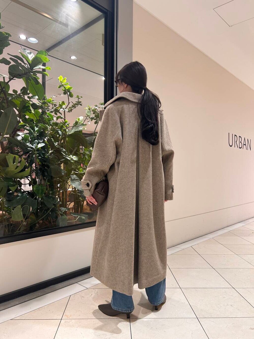 ブルー系のデニムパンツ、ブラウン系のニット/セーター、ブラウン系のブーツを着用したレディースの冬コーディネートの2枚目の写真