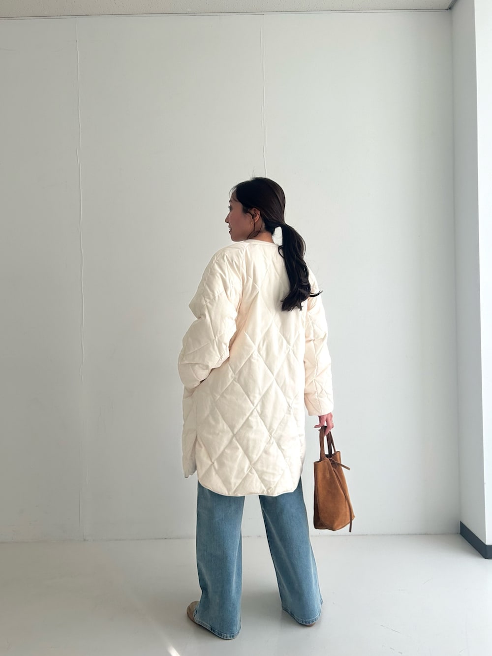 ホワイト系のカーディガン/ボレロ、ホワイト系のダウンジャケット/コート、ベージュ系のトートバッグを着用したレディースの秋コーディネートの2枚目の写真