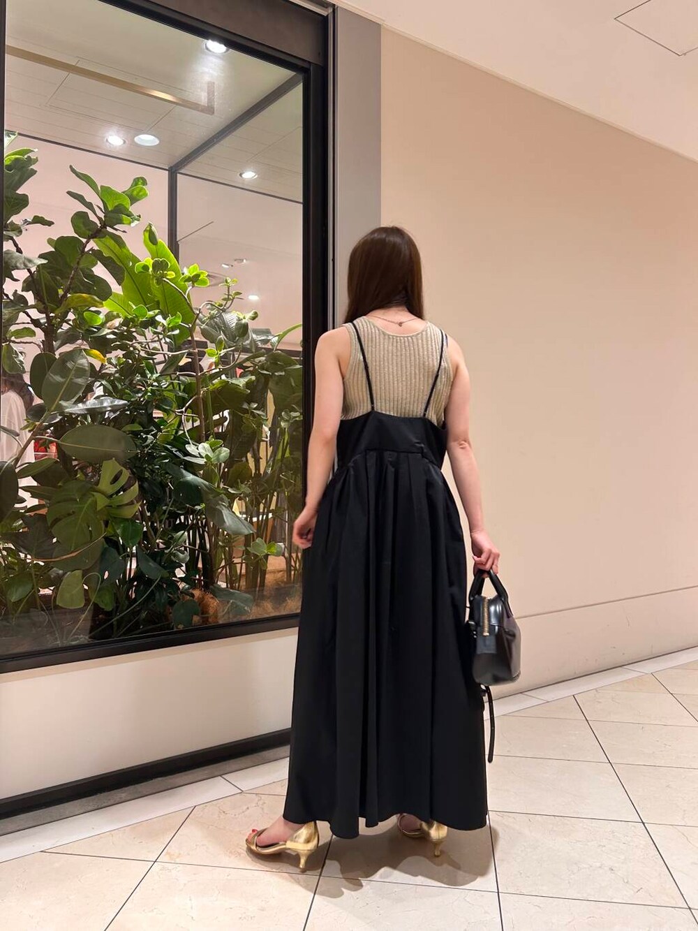 ブラック系のショルダーバッグ、ブラック系のワンピース、ベージュ系のタンクトップを着用したレディースの夏コーディネートの2枚目の写真