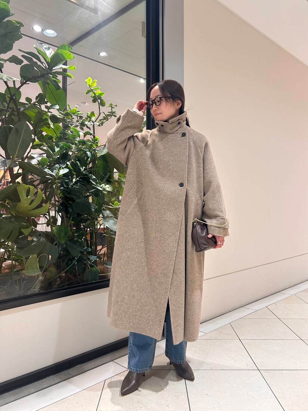 ブルー系のデニムパンツ、ブラウン系のニット/セーター、ブラウン系のブーツを着用したレディースの冬コーディネートの3枚目の写真