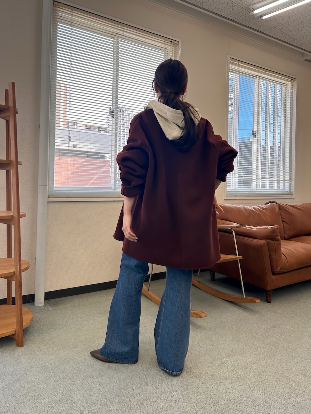 ブラウン系のステンカラーコートを着用したレディースの秋コーディネートの2枚目の写真