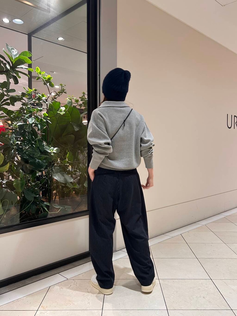 ブラック系のショルダーバッグ、ブルー系のその他パンツ、グレー系のニット/セーターを着用したレディースの冬コーディネートの2枚目の写真