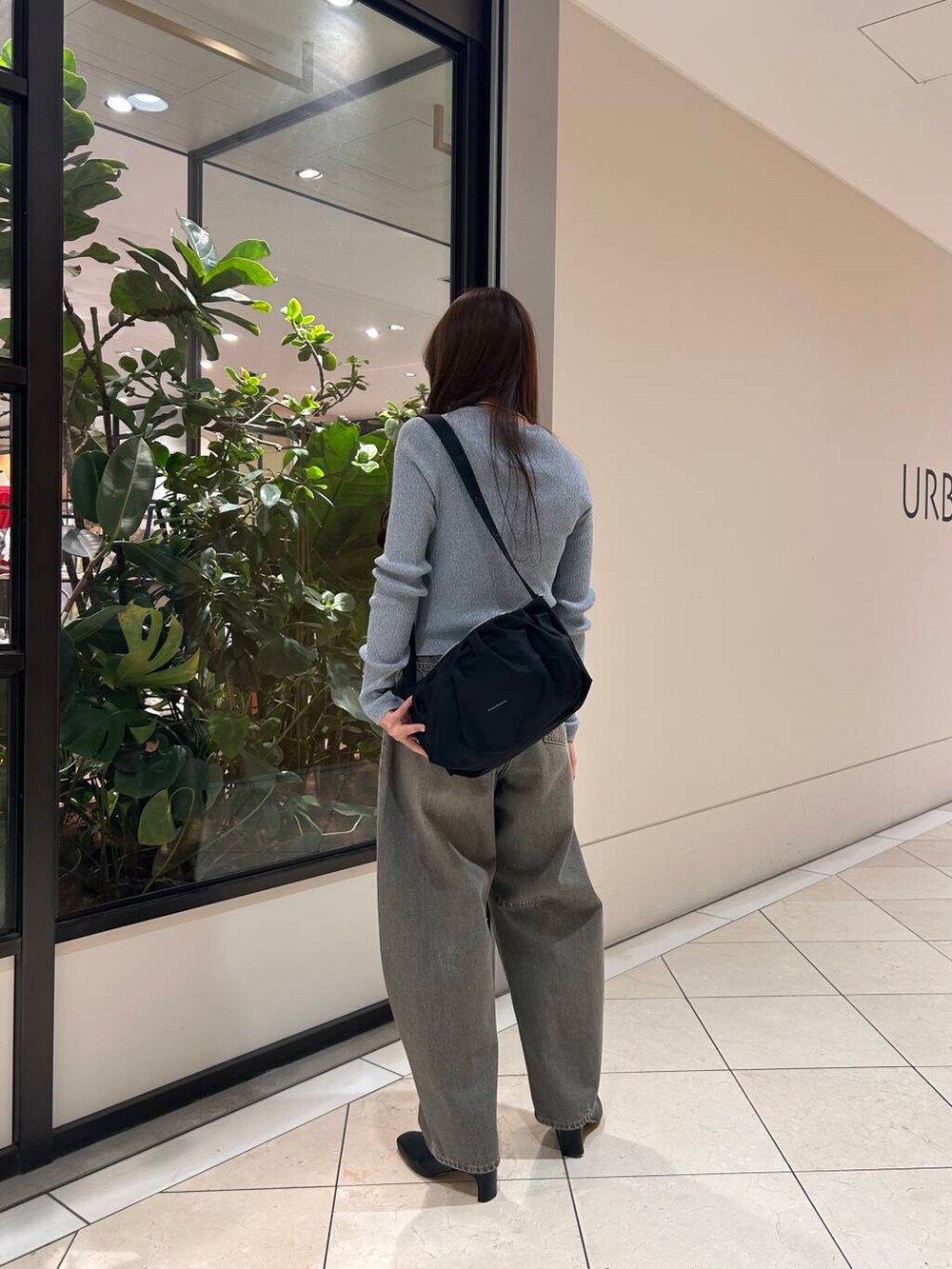 グリーン系のデニムパンツ、ブルー系のニット/セーター、ブラック系のブーツを着用したレディースの冬コーディネートの2枚目の写真