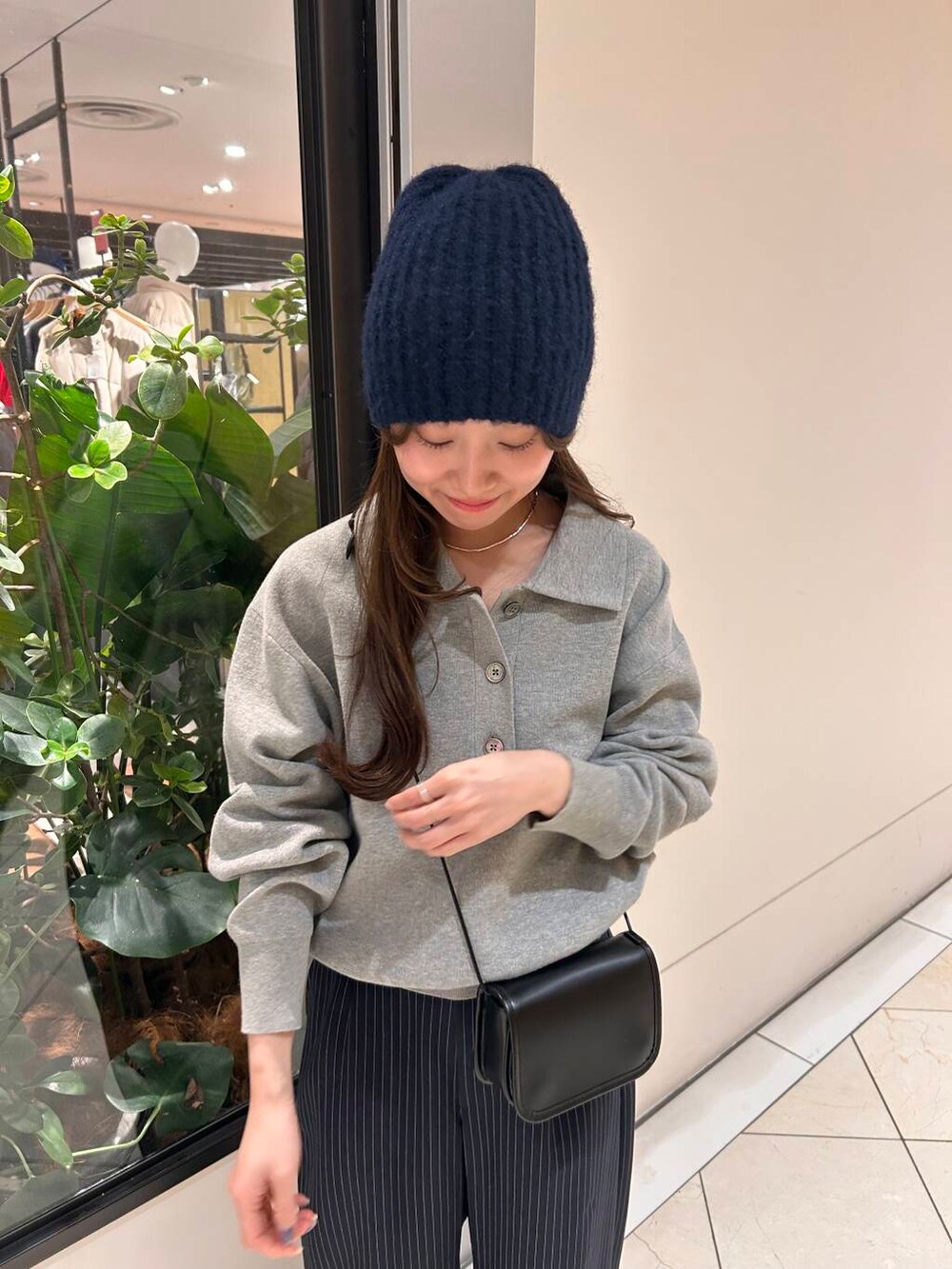 ブラック系のショルダーバッグ、ブルー系のその他パンツ、グレー系のニット/セーターを着用したレディースの冬コーディネートの3枚目の写真