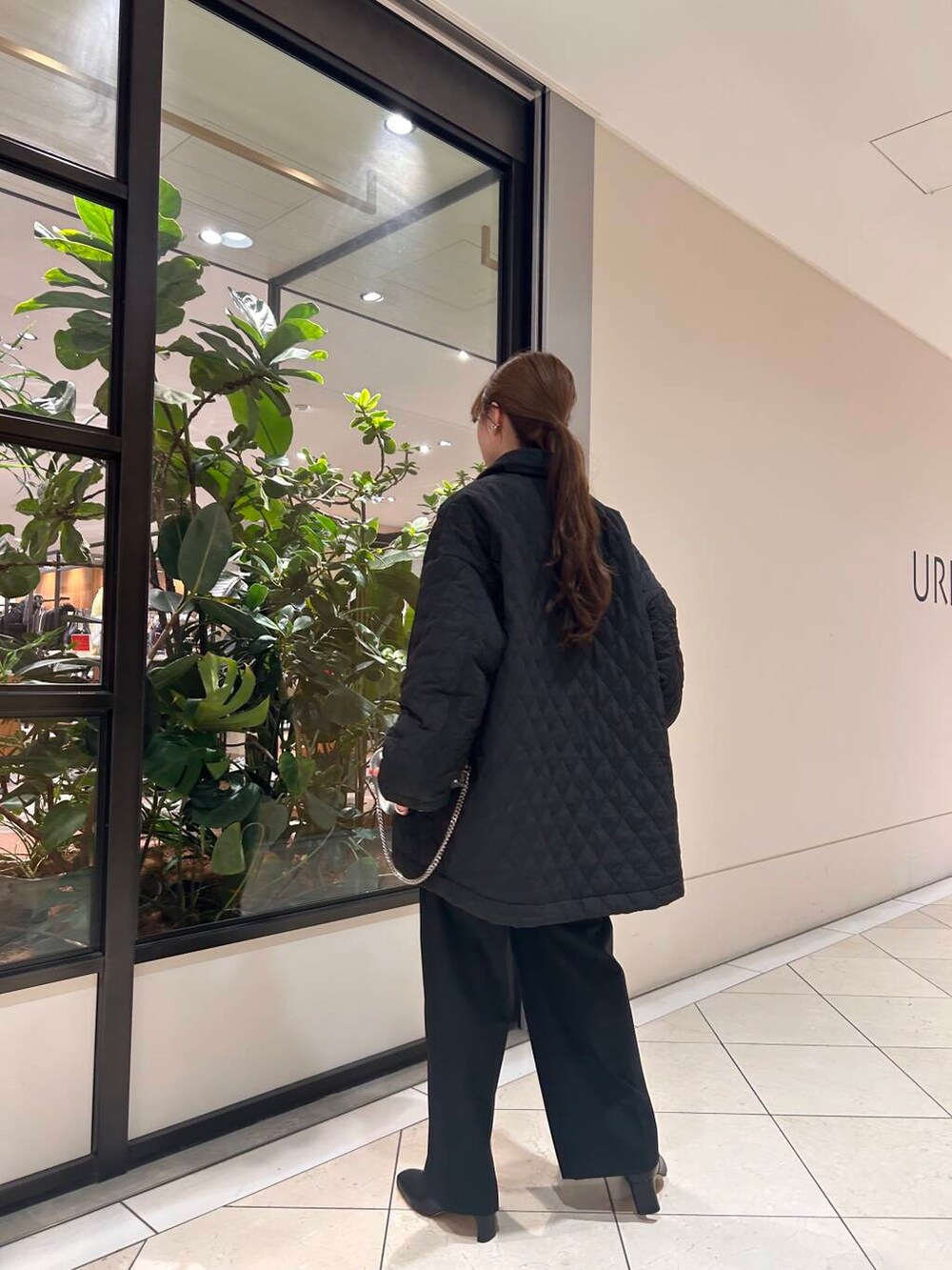 ブラック系のその他パンツ、ホワイト系のTシャツ/カットソー、シルバー系のショルダーバッグを着用したレディースの冬コーディネートの2枚目の写真