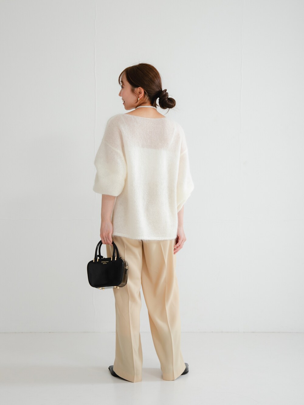 ブラック系のブーツ、ベージュ系のその他パンツ、ブラック系のショルダーバッグを着用したレディースの冬コーディネートの3枚目の写真