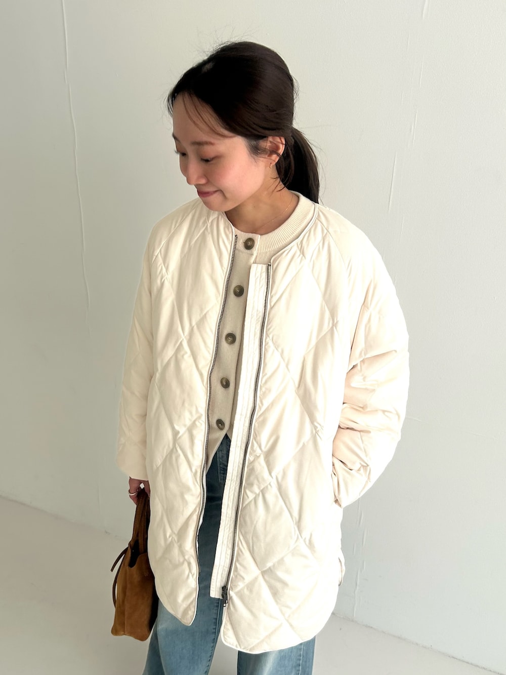 ホワイト系のカーディガン/ボレロ、ホワイト系のダウンジャケット/コート、ベージュ系のトートバッグを着用したレディースの秋コーディネートの3枚目の写真