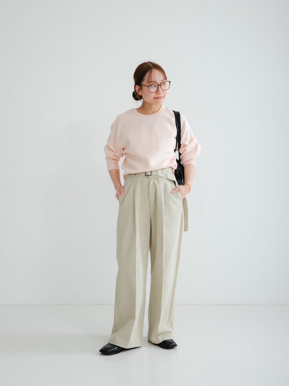 ピンク系のニット/セーター、ブラック系のローファー、ブラウン系のメガネを着用したレディースの冬コーディネートの2枚目の写真