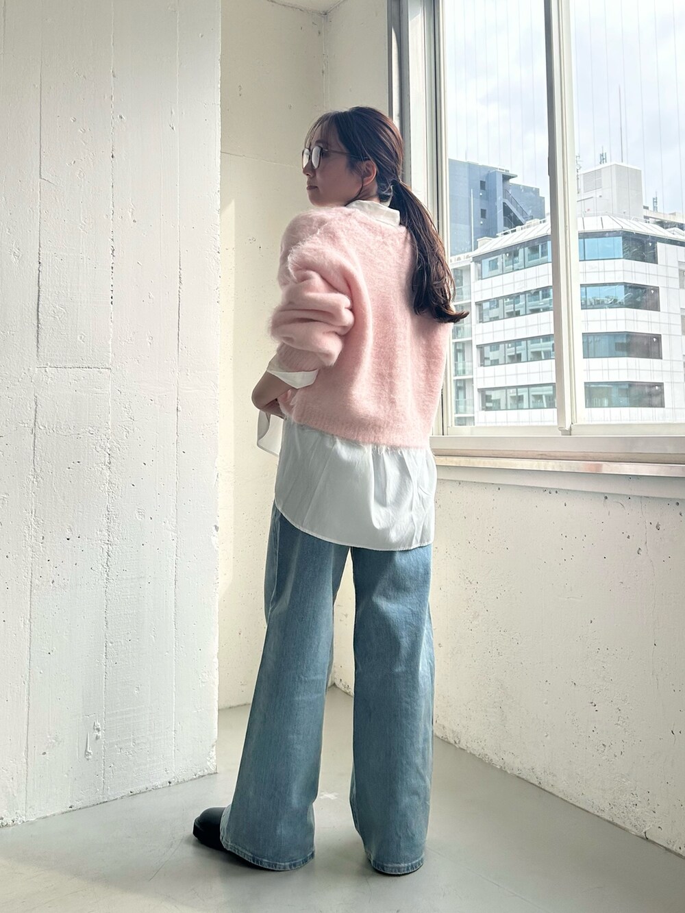 ブルー系のデニムパンツ、ブラック系のブーツ、ホワイト系のシャツ/ブラウスを着用したレディースの冬コーディネートの2枚目の写真