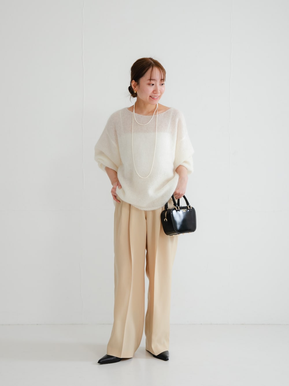 ブラック系のブーツ、ベージュ系のその他パンツ、ブラック系のショルダーバッグを着用したレディースの冬コーディネートの2枚目の写真