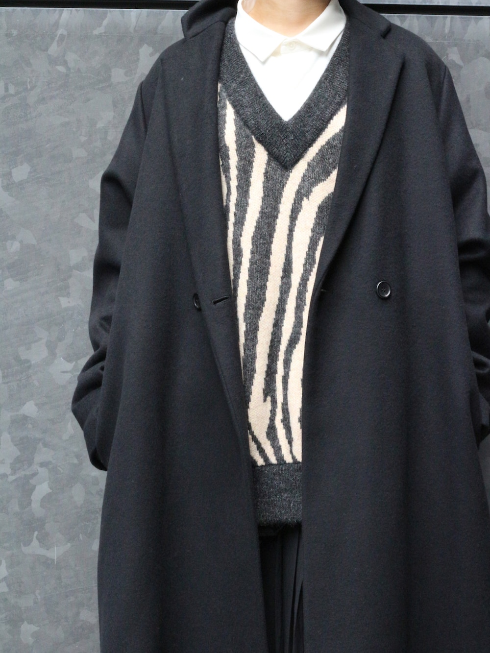 ブラック系のチェスターコートを着用したレディースの冬コーディネートの2枚目の写真