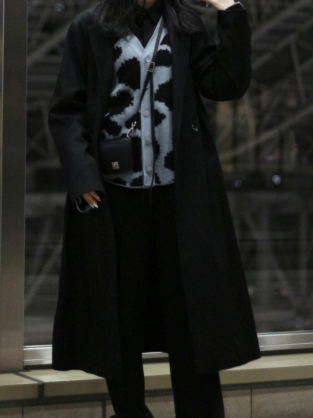 ブラック系のチェスターコートを着用したレディースの冬コーディネートの2枚目の写真