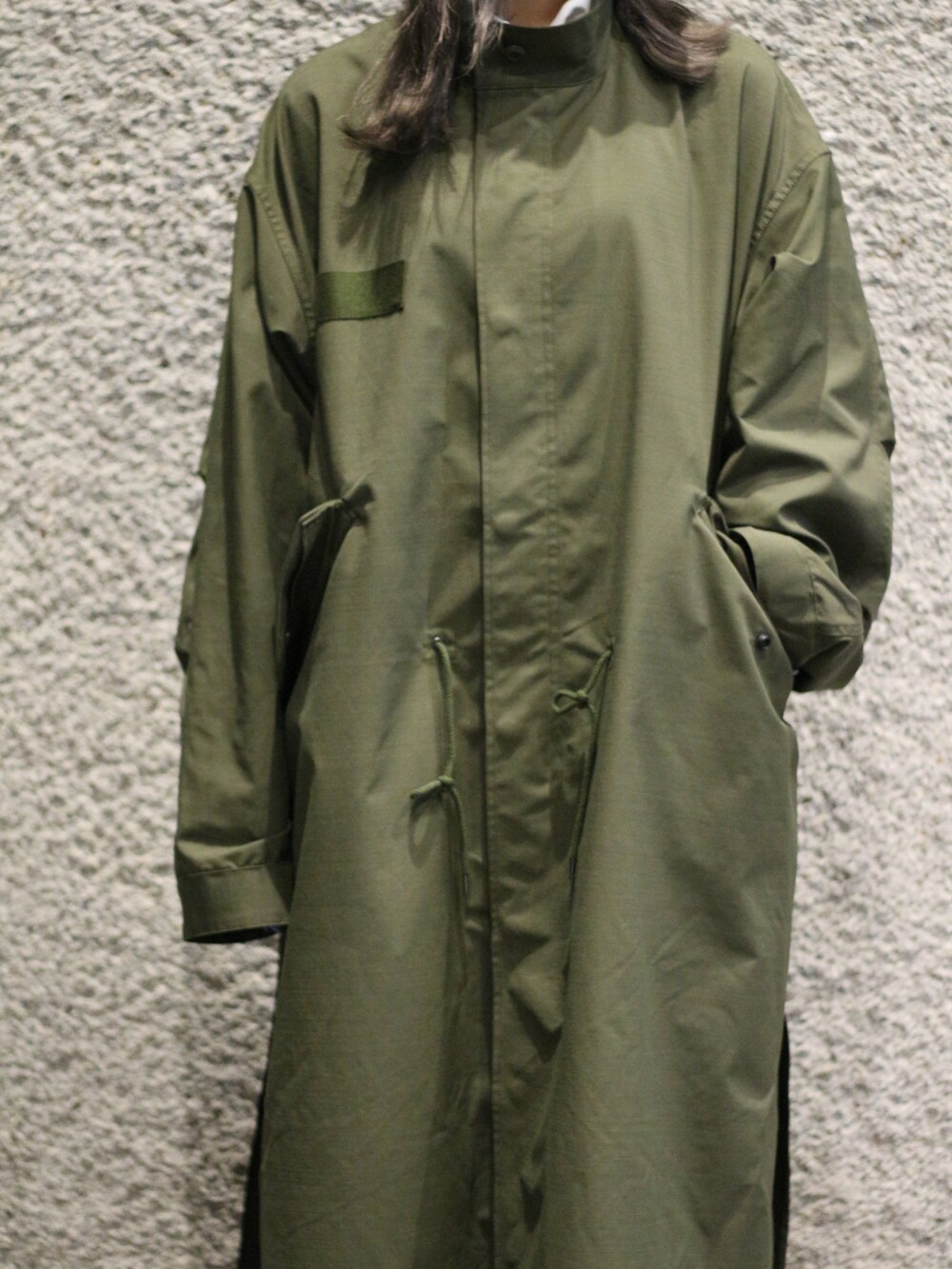 グリーン系のモッズコートを着用したレディースの冬コーディネートの2枚目の写真