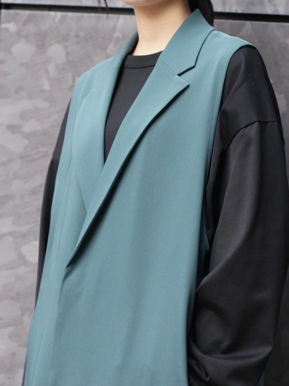 グリーン系のテーラードジャケット、ブラック系のTシャツ/カットソー、ベージュ系のスラックスを着用したレディースの春コーディネートの3枚目の写真