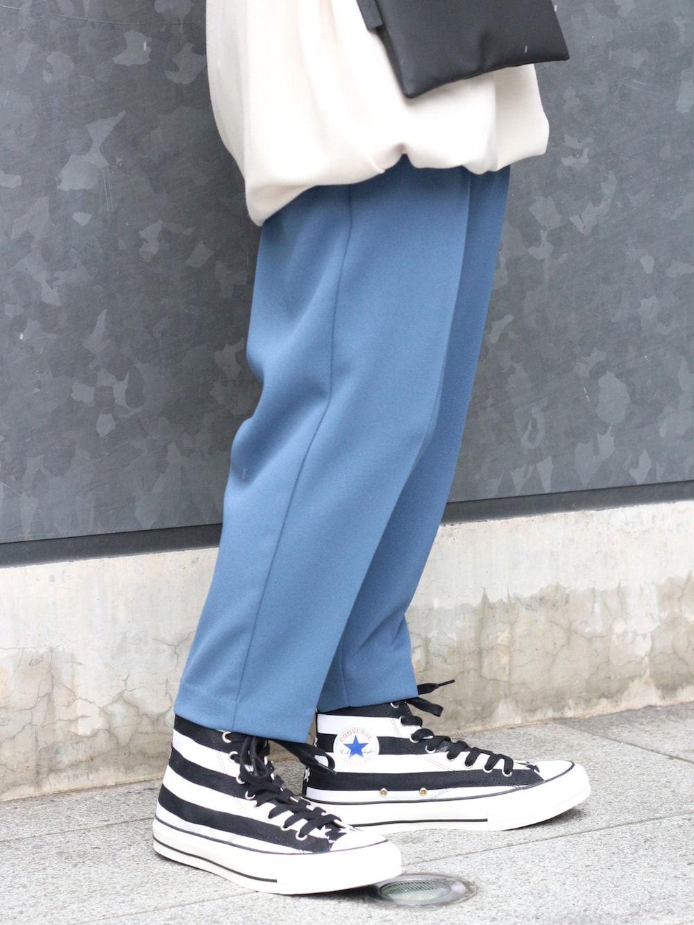 ホワイト系のトップス、ブラック系のボディバッグ/ウエストポーチ、ブルー系のスラックスを着用したレディースの冬コーディネートの4枚目の写真