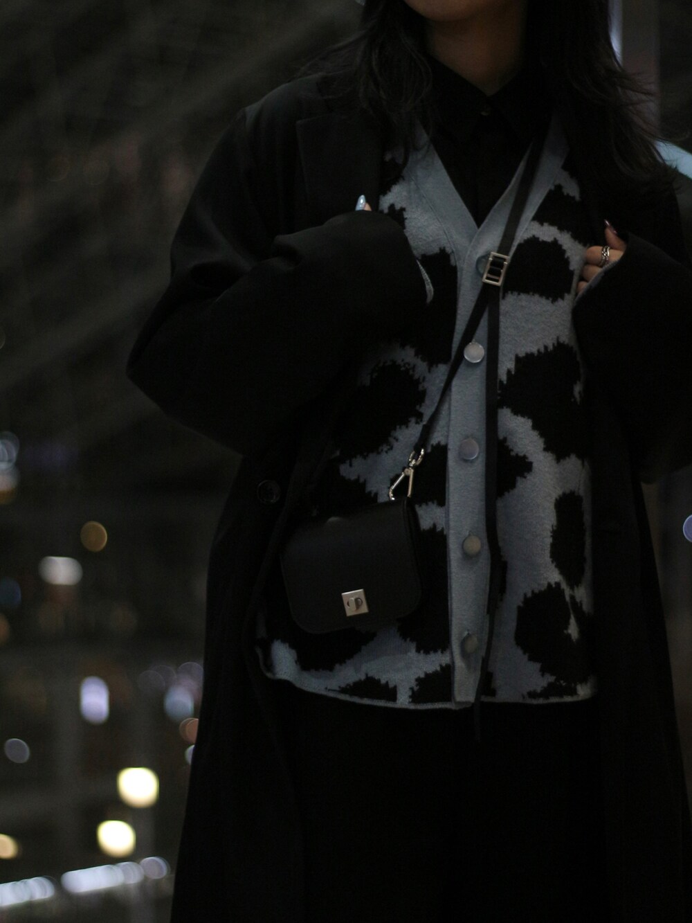 ブラック系のチェスターコートを着用したレディースの冬コーディネートの3枚目の写真