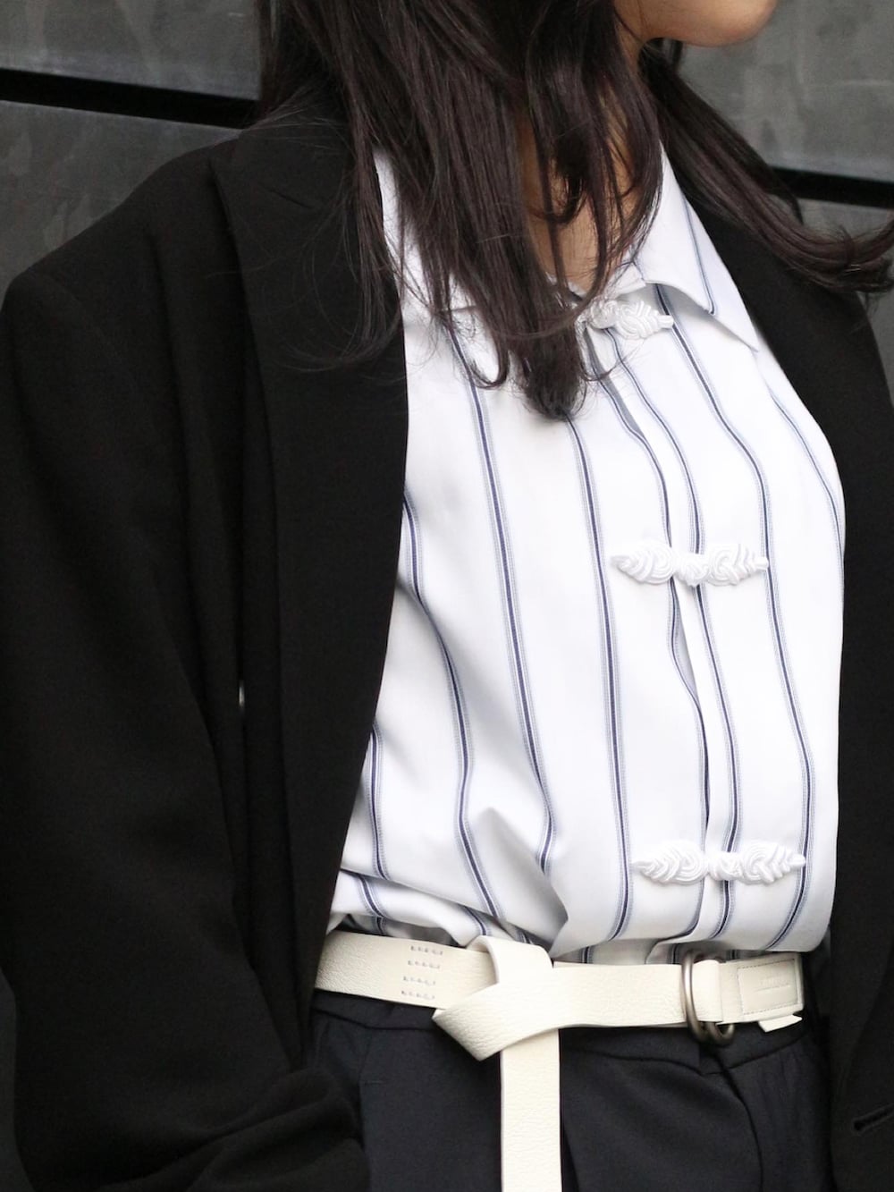 ホワイト系のシャツ/ブラウス、ブラック系のテーラードジャケット、ブラック系のスラックスを着用したレディースの冬コーディネートの2枚目の写真