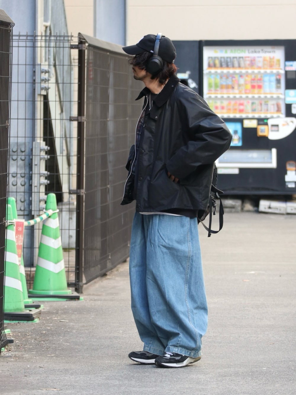 ブラック系のブルゾン、ブルー系のデニムパンツを着用したメンズの冬コーディネートの2枚目の写真