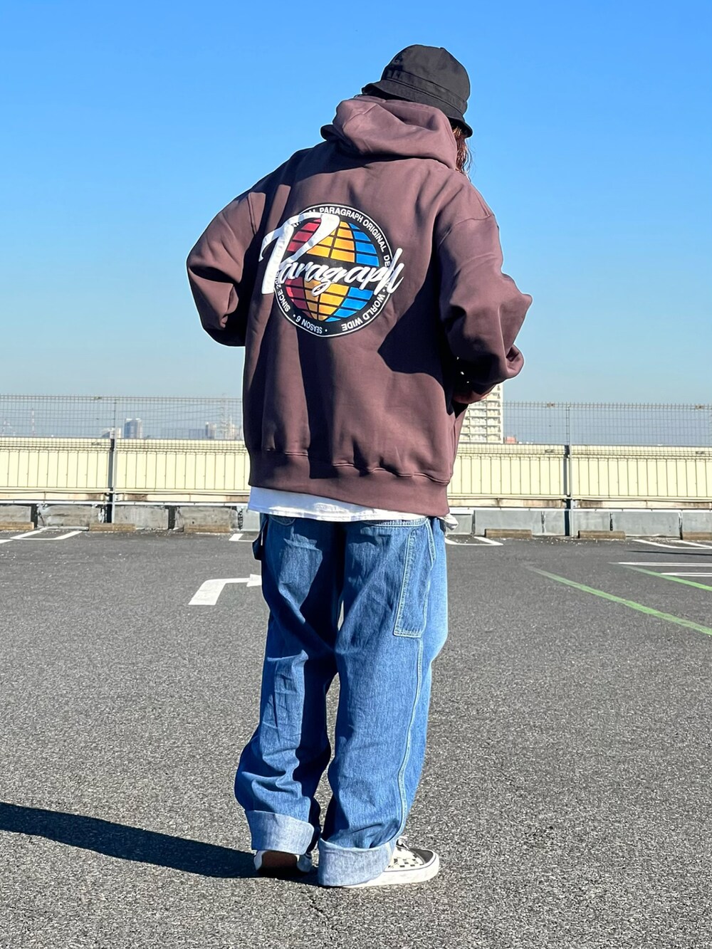 ブラウン系のパーカー、ブラック系のスニーカー、ブラック系のハットを着用したメンズの秋コーディネートの3枚目の写真