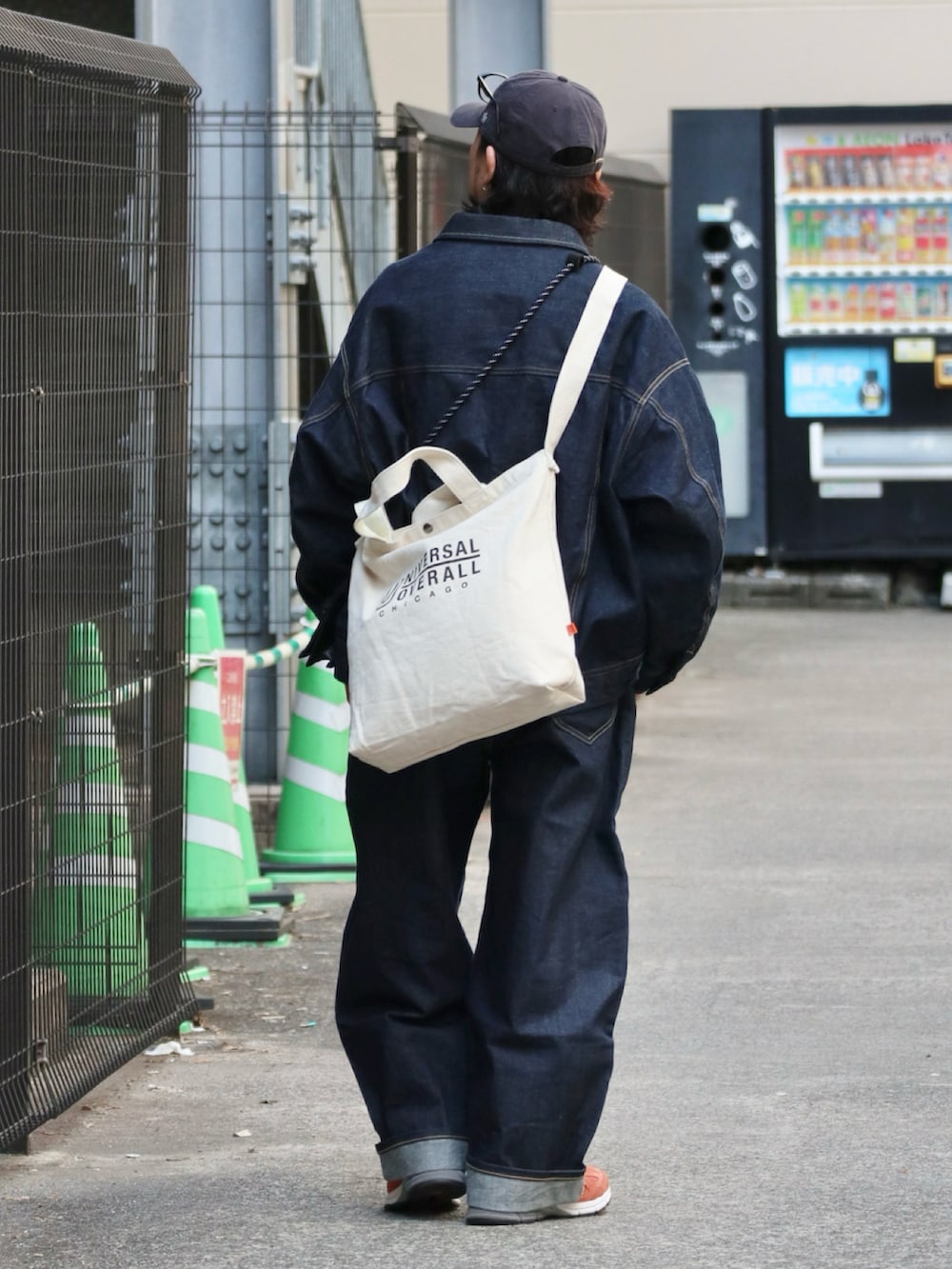 ブルー系のデニムジャケット、ブルー系のデニムパンツ、オレンジ系のスニーカーを着用したメンズの春コーディネートの3枚目の写真