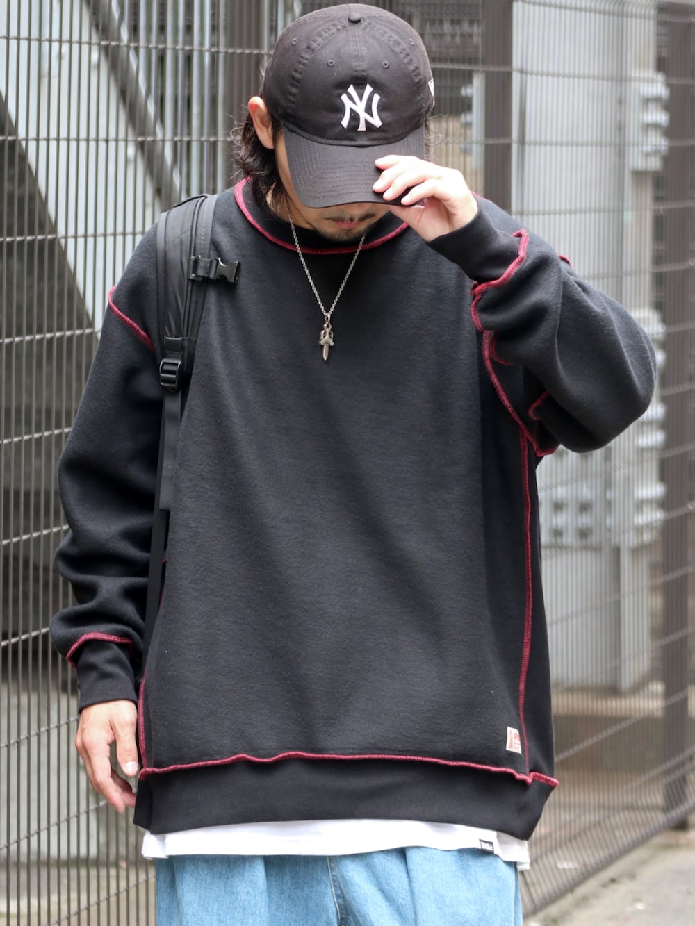 ブラック系のスウェット、ブルー系のデニムパンツを着用したメンズの秋コーディネートの2枚目の写真